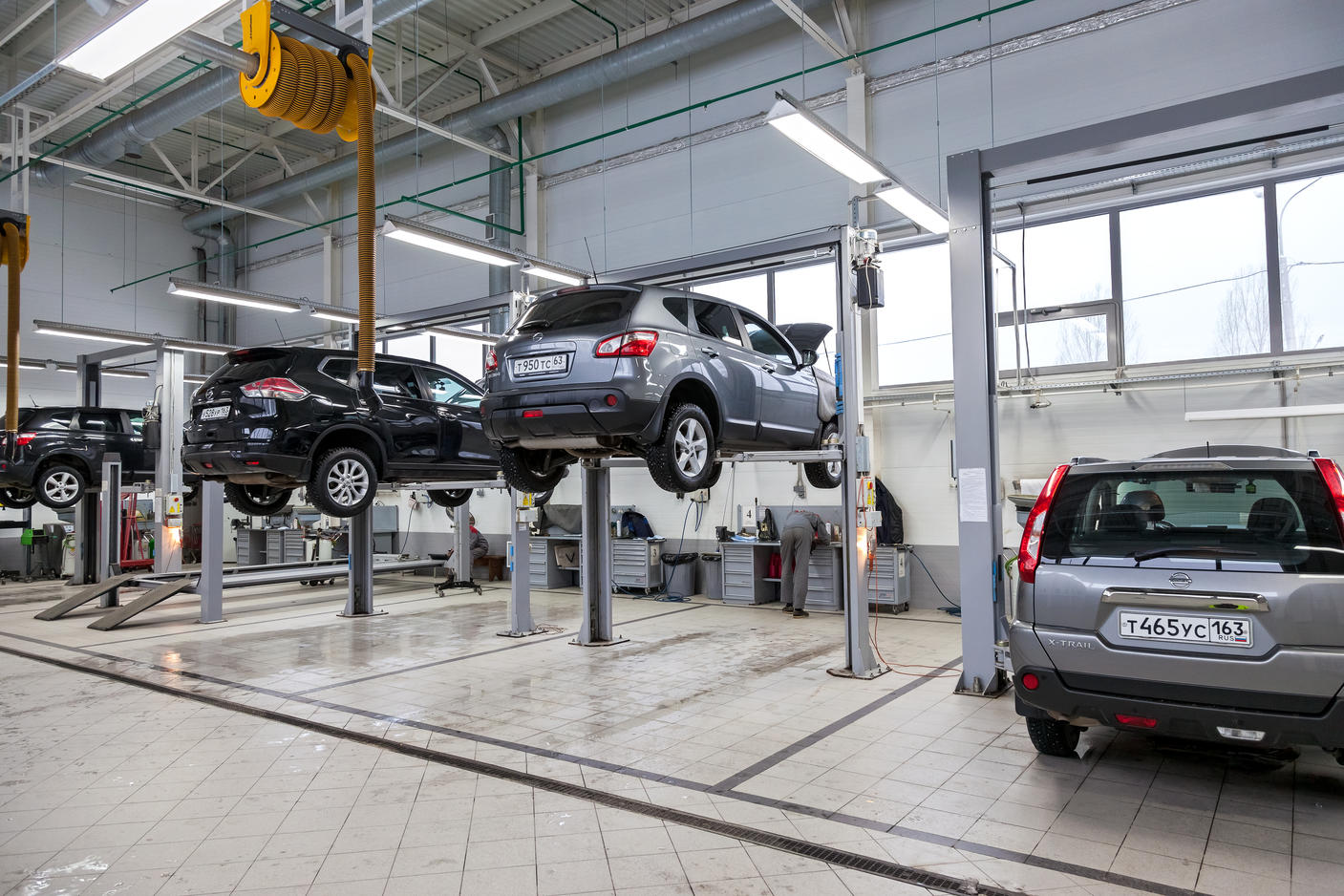 Cars on lifts at Nissan dealership in Russia.
